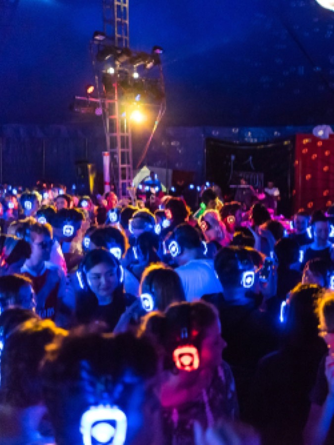 Silent disco huren in Groningen: dansende mensen met lichtgevende koptelefoons